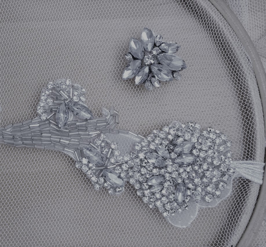 Complementos de pedrería plateada con motivos florales sobre una base de tul.
